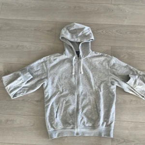 Grå zip tröja - En grå zip tröja från hm som är i toppskick! Har haft tröjan i 4-5 månader och har knappt användt den. Har kanske använt den 5 gånger Max så den är i nyskick! Hör av er om ni har några funderingar