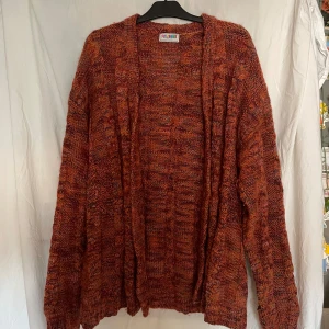 Stickad kofta  - Jättesöt lång stickad kofta i en massa färger med söta knappar. Rätt så nopprig, men annars i bra skick. Passar storlek S-L