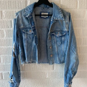Croppad jeansjacka - Croppade jeansjacka med slitningar. Sparsamt använd. Bra skick Köparen står för frakten 