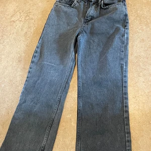 Svarta/gråa breda jeans  - Svarta/gråa breda jeans. Strl 134 och aldrig använda . Säljer pga jag inte gillar hur dom ser ut. Fickor där bak och små där fram. Dock passar dom med allt 🙂