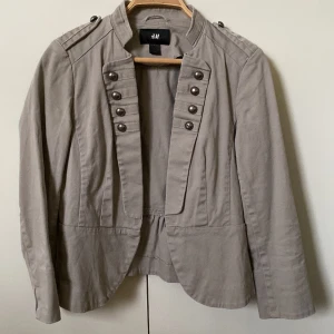 Jättefin tunn jacka!!! - Säljer min fina tunna jacka från H&M. Fina detaljer och material. Fint skick är ej använd så mycket, nån liten söm som lostnat/sitter löst (men inget som stör funktionen). Perfekt till våren/sommaren. Storlek 38, sitter som en xs! 