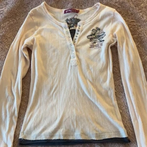 Rosa henley topp med detaljer - Jättefin rosa henley topp med coola detaljer på.💕 Säljer då den inte kommer till använding. Är egentligen barnstorlek men passar som xs. Kanske är lite kort i armarna men annars passar den:)