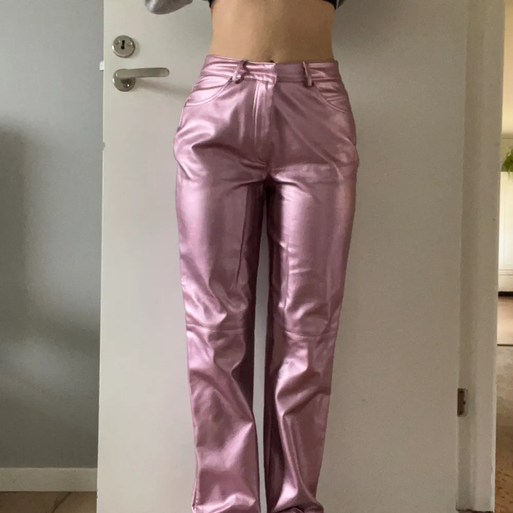Coola läderbyxor i rosa metallic Använda fåtal gånger, jättebra skick  Normala i storleken. Har raka ben och är höga i midjan.  Perfekta till fest nu i vår och sommar!!. Jeans & Byxor.