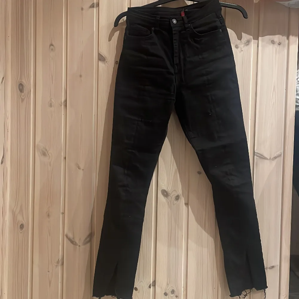 Ett par fina svarta jeans, storlek 28. De har ett snitt längst ner vid fötterna!! De är stretchiga och sitter jätte fint på en!!🖤❤️🖤❤️. Jeans & Byxor.
