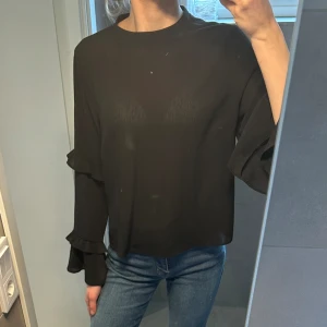Blus  - En långärmad svart blus med breda volang ärmar🤩 Den är från Primark i storlek 40 men väldigt liten för att vara i storlek 40