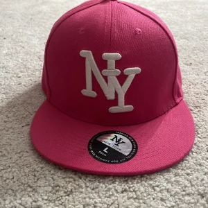 New york keps  - En rosa new york keps ganska stor men jävligt najs om man inte vill förstöra håret. pris kan diskuteras!💗