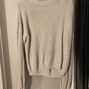 Grå tröja  - En grå långärmad stickad tröja i strl M