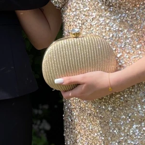 Guldig väska  - Säljer denna gulliga väskan som passar perfekt inför balen✨ bra skick och lagom utrymme i väskan. Axelbandet kan användas som den är eller läggas in utan problem i själva väskan ifall man bara vill hålla väskan i handen!