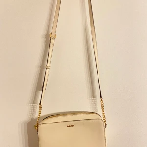 DKNY Väska - DKNY väska i äkta läder i kräm vit i nyskick. Om fler bilder önskas är det bara att skriva! Vid snabb affär kan pris diskuteras! 