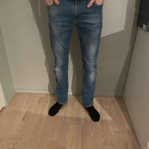 Ett par snygga blåa nudie jeans i storlek 31/32, men passar också i waist 29. Har en liten defekt (se bild 3) men är ändå 8/10 skick. Modellen är runt 180. Nypris på dom här är runt 1600 och vårt pris är 349 kr! Hör av dig vid minsta fråga!