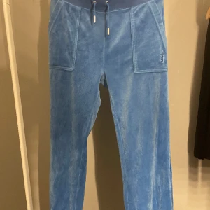 Juicy couture byxor - Blå jättefina juicy byxor, dom är lite upptrampade längst ner ” lite tunnare tyg” kan skicka bild på det om ni är intresserade, dom har också 2 små fläckar på sidan av byxorna, dom syns inte väl, annars jättebra skick💙💙