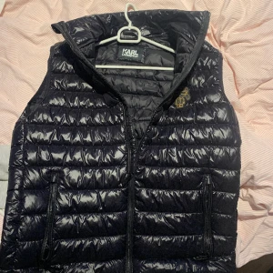 KARL LAGERFELD VÄST - Size S Nypris 2195 kr Glansig stilren väst som är perfekt för våren och sena sommarkvällar.