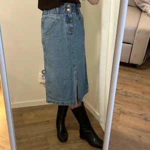 Jeanskjol - Jeanskjol med många fickor, liten slit i fram och resår i midjan