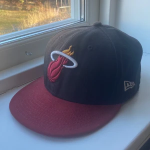 New era keps - Feeet svart och vinröd kepa från new era med laget miami heat broderat framtill och en liten NBA logga bak🏀. ⚠️Viktigt⚠️ den är inte en snapback och har därför en fast storlek. Inga skador eller brister. Ställ gärna frågor!💬