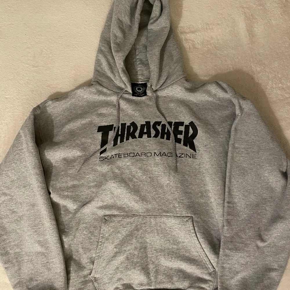 Grå, äkta Trasher Skate hoodie av högt kvalitet. Originalpris minst 750kr. Knappt använd, därför inga skador. Mjukt material inne i tröjan och tjock och mjukt material utanför. Stor luva! Lite oversized.. Hoodies.