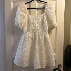 Vit klänning  - Supersöt klänning som passar perfekt till studenten/ skolavslutning🌸 Klänningen är i ett ”buckligt” material och har dragkedja baktill💓