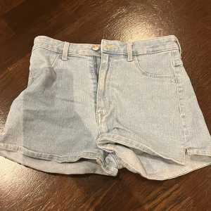 2st jeans shorts - Säljer 2st jeans shorts. Ena är ljusblå och andra svart. Båda kan köpas men en kostar 70. Kort, fin, söt. Finns ett litet snitt på sidan av det blåa paret. Köp!❣️