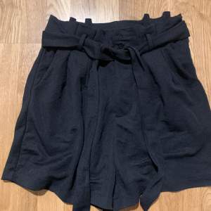 Svarta flowy shorts med knytskärp, inköpta på bikbok och endast används en gång, storlek 42 men passar oxå 40 pga knytskärpet.