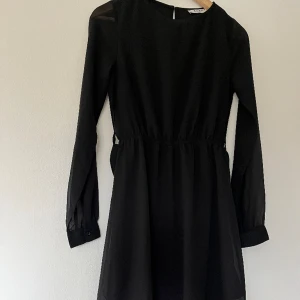 Svart klänning från NA-KD - Klänning från NA-KD som är använd en enstaka gång. Band i midjan som kan sättas både fram och bak, och går och reglera i storlek. 