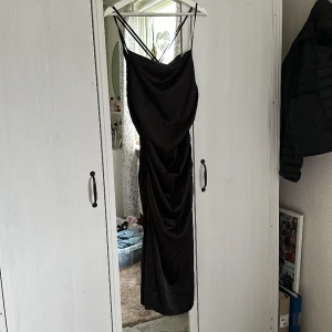 Svart klänning  - Svart klänning , aldrig använd endast testad.  Köpt från bonprix Storlek 38 , passar mig som är S/M 36/38  Banden är korsade i ryggen  Dragkjedja i sidan men väldigt stretchig i sidorna 