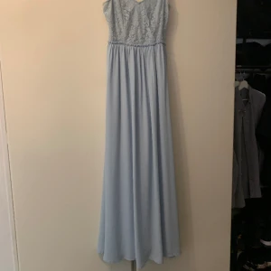 Ljusblå festklänning  - Jättefin ljusblå festklänning/balklänning, tunna band och fin spets upptil, skön och flowy nertill. Hade den endas en gång när jag var brudtärna, passar perfekt även som bröllopsgäst.