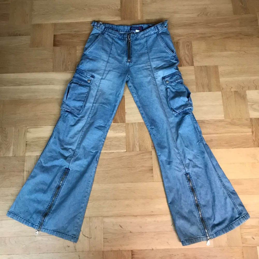 Unika Lågmidjade utsvängda jeans med drag kedjor, fickor och massa andra detaljer 🌻 Midjemått rakt över = 40 cm Innerbenslängd = 81 cm Längden på hela byxorna = 104 cm. Jeans & Byxor.