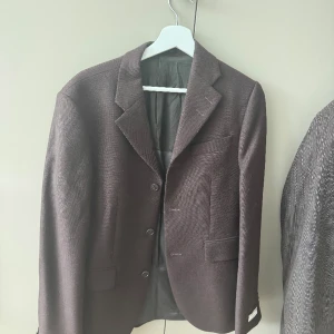 Tiger of Sweden kavaj - Super snygg kavaj från Tiger of Sweden i en mörkbrun färg. Använd ca 5 gånger, så i fint skick. Material ser ni på en av bilderna. Size 46, sitter perfekt, lite åt det större på mig som vanligtvis har 36/s.