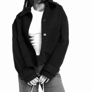 Svart Nelly kappa  - En jättefin svart kappa. Aldrig använd på grund av att jag fick två likadana. Nyskick, normal i storleken. Köpt för 699kr på NELLY pris kan diskuteras!