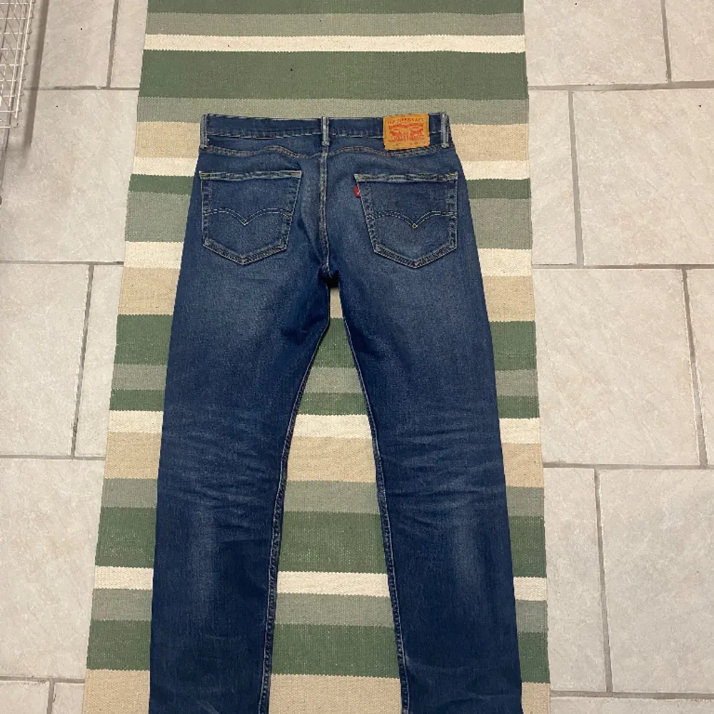 Säljer mina Levis 502 vintage mörkblåa jeans för jag inte använder dom. Byxorna är i jättefint skick, endast en spricka i lappen på baksidan av byxan - se bild. Midjan är strax över 40 cm och längden är runt 100cm. Kan gå ner i pris vid snabb affär! . Jeans & Byxor.