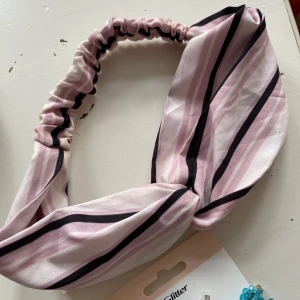 Randigt hårband  - Rosa, vit och svart- randigt hårband. Aldrig använt. Bara att fråga om det är något du undrar! Kan mötas på Järntorget i Göteborg eller skicka, köparen står för frakt.