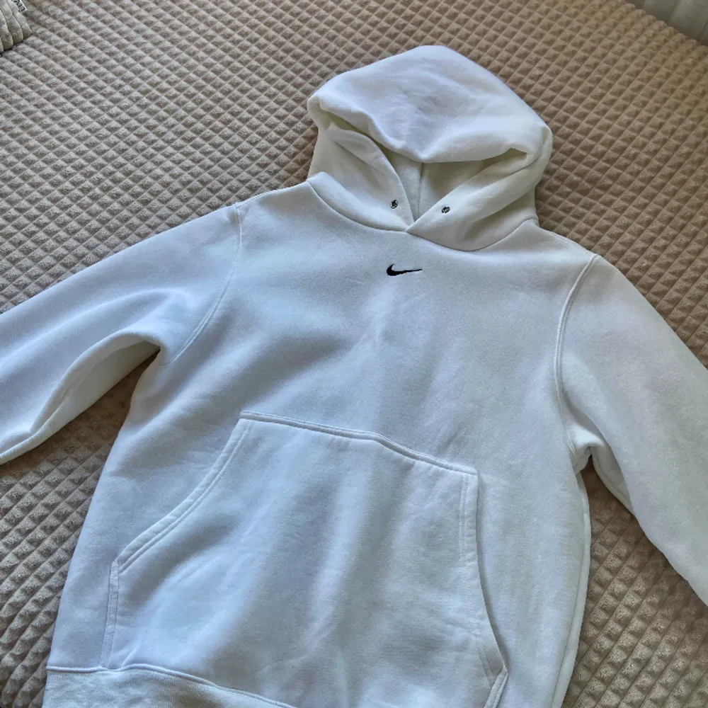 Mysig stil med denna klassiska vita Nike-huva! Med material av bomull och ikonisk Nike-logotyp är denna huva perfekt för träning eller vardagsbruk.. Hoodies.