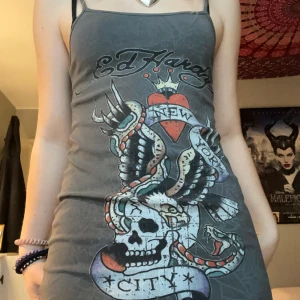 EdHardy linne/klänning  - En grå EdHardy x Urban Outfitters klänning i storlek S. Plagget har en fin design och som man kan se på sista bilden mycket detaljer. Klänningen är dock väldigt kort så den också kan användas som långt linne. Jag är dock 177cm så man får avgöra själv