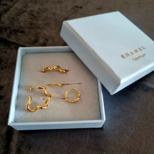 Enamel Copenhagen örhängen - Enamel Copenhagen 18k guld sterling silver, oanvända, Curly Hoops 690kr nypris 950kr Hoops Holly L 490kr nypris 750kr               Paketpris 1100kr nypris 1700kr