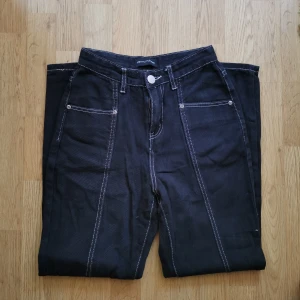 Svarta byxor från pretty little things - Svarta byxor i tunnare jeansmaterial med vita sömmar.  EU 32, väldigt fint skick (aldrig använda av mig och nästan oanvända innan det). Hämtning, annars betalas frakt av köparen. Bara att skriva vid frågor! 🌻