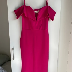 Finklänning rosa  - Rosa finklänning med axelband + volang på armen. Jättefin!! Ny med prislapp kvar. Säljer då den tyvärr är för liten för mig. 