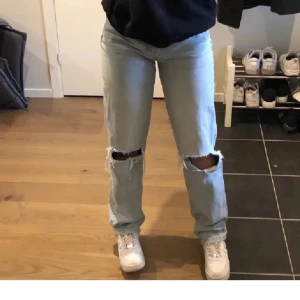 Jeans med hål - OBS LÅNAD BILD! Blåa jeans med hål i knäna från ginatricot i gott skick storlek 34