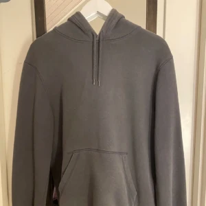 Mörkgrå hoodie - En mörkgrå hoodie som är väl använd, kan vara lite nopprig.