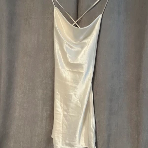 Satinklänning - Oanvänd med lappar kvar. Vanlig satinklänning med låg rygg, finare passform i verkligheten än på bild! 