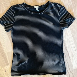 T-shirt randig - Basic tshirt, svart med vita ränder. Bra skick. Stretchig. 