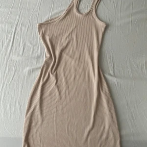 Beige miniklänning - Assymetrisk miniklänning. Beige och ribbad. Använd en gång. 