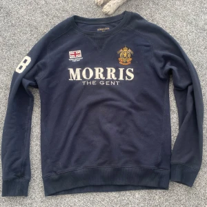 Mörkblå sweatshirt  - Säljer en så snygg sweatshirt med tryck på från Morris Gents😻Den har 68 broderat på ena armen & trycket på framsidan är oxå broderat🤩Strl.M, passar flera. I bra använt skick, liten fläck på baksidan (se bild 5), går nog bort i tvätten. Nypris:1 299kr