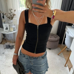 Svart topp  - Så snygg svart korsett liknande topp som formar sig efter kroppen så snyggt😇passar till finare tillfällen!