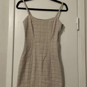 Klänning  - Beige rutig klänning i storlek xxs. Använd 1 gång. 