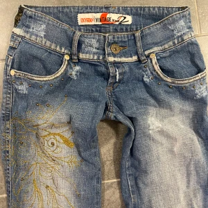 Vintage y2k 00s lågmidjade bootcut jeans med broderi fickor och detaljer - Innerben: ca 77 cm. Midja: 35/36 cm. För små på mig så har inga bilder på. Fint skick på dessa vintage jeansen förutom några lösa trådar och slitningar(tror slitningarna på benen ska vara där). Tryck gärna på köp nu. Står strl M men är mer som en S.💕
