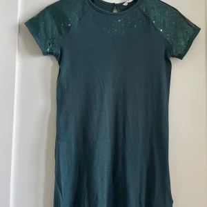 Grön klänning med paljett armar🙌🏼 - Stl. 140-152, 10-12 år  75cm lång Mycket bra skick! Inga slitningar eller skador. 