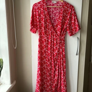 Sommarklänning  - Fin röd klänning med knyte i midjan. Fin till enkla men även finare tillfällen. Använd någon enstaka gång. Bra skick