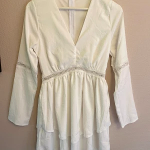 Vit sommarklänning - Storleken är S men är tajt runt de stickade i midjan. Passar xs-s beroende på midjemått. Aldrig använd då den inte passade. Perfekt sommarklänning!