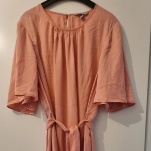 Oanvänd sommarklänning, H&M, 46 - Aldrig använd men prislappen är borta. Vida ärmar, slutar över knät, knyts i midjan.