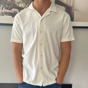 Frotté piké - Säljer schysst vit frotté piké med knappar från East West. Nyskick och normal i storleken (M) 🔥 hör av er vid frågor eller funderingar!