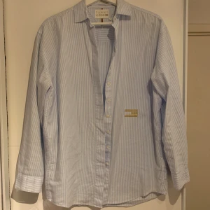 Randig blå skjorta 👔  - Snygg skjorta inför sommaren med en snygg guldig brodyr, använd fåtal gånger! Klicka gärna på köp nu eller kontakta 💐💞🌸🩷